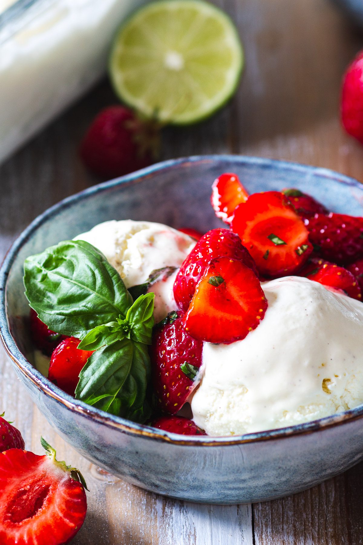 jordgubbar marinerade med lime och basilika i en skål med vaniljglass