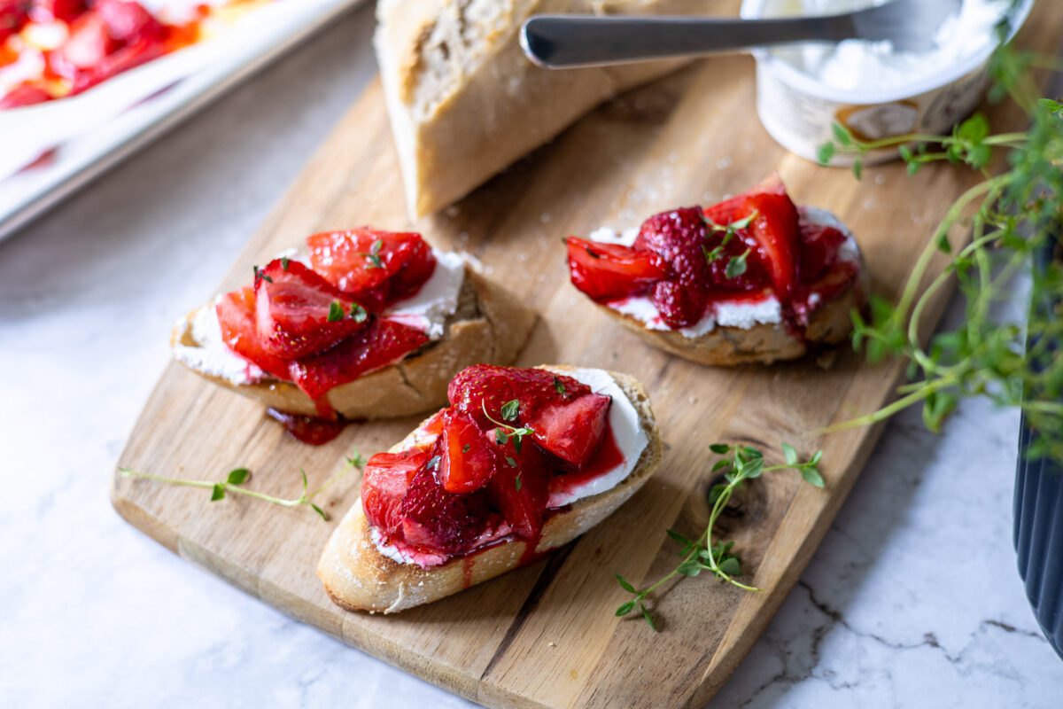crostini på skärbräda med getostkräm och rostade jordgubbar