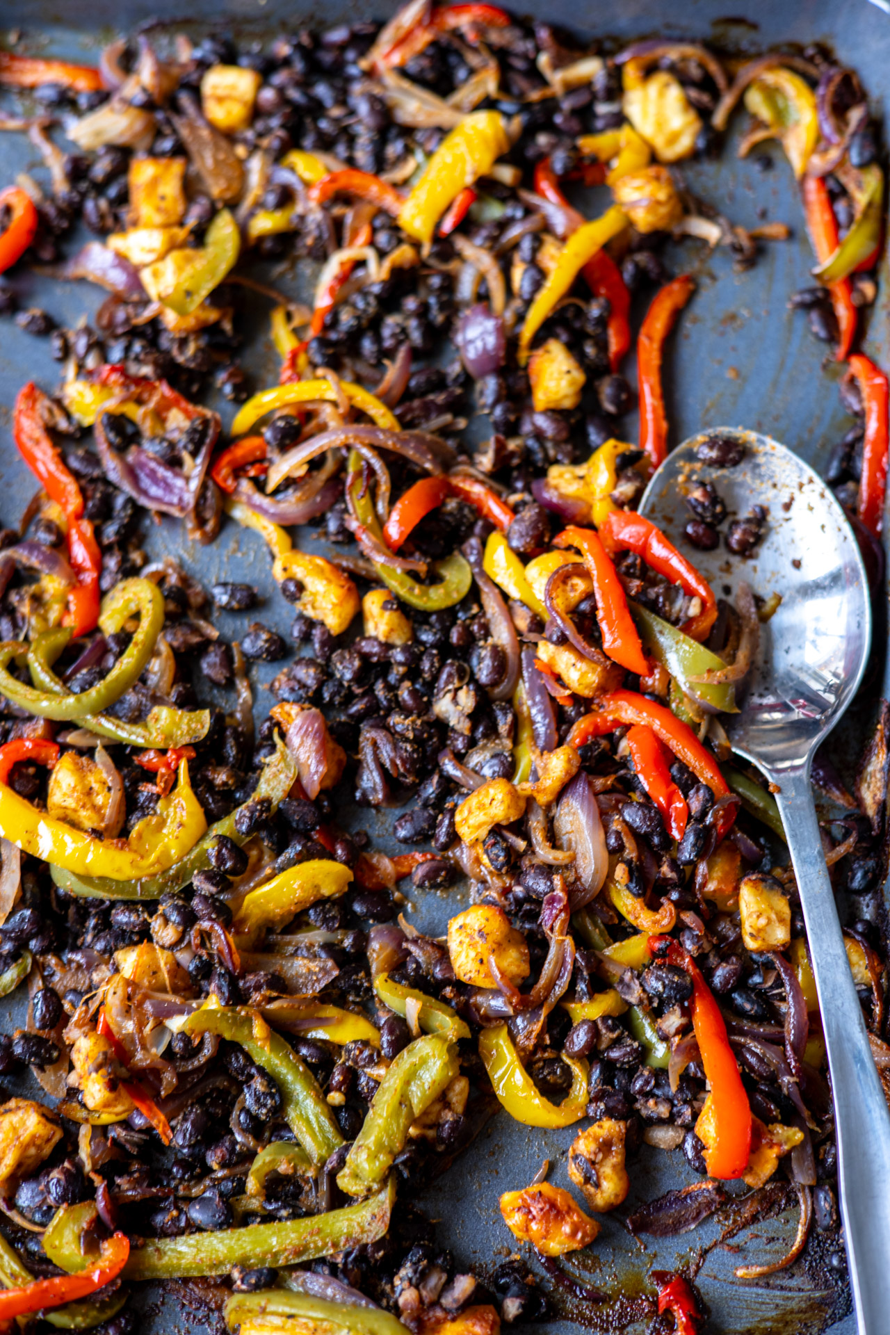 ugnsrostade grönsaker, svarta bönor och halloumi på plåt