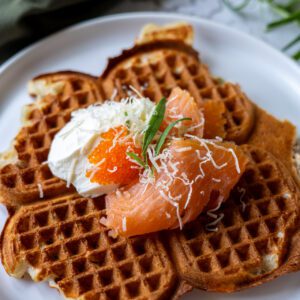 våffla på tallrik med crème fraìche, lax och stenbitsrom